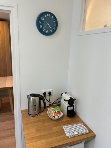 a clock on a wall above a table with a toaster at Studio number 5 in Pantin