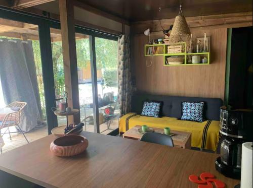 un salon avec un lit et une table dans l'établissement Chalet cozy dans Village au cœur des pins, parking gratuit, à Onesse-et-Laharie