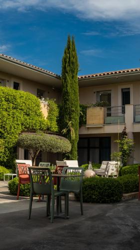 a table and chairs in front of a building at Patio De Violette in Uzès