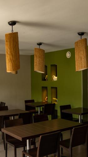 a restaurant with tables and chairs and green walls at Patio De Violette in Uzès