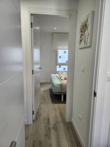 a hallway with a room with a bed and a mirror at Summer Malpica - calma junto al mar in Malpica