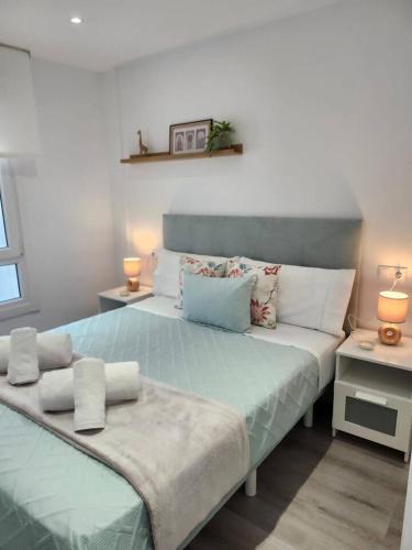 a large bed in a room with two tables at Summer Malpica - calma junto al mar in Malpica