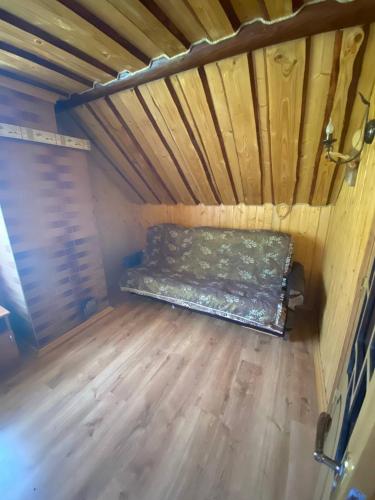 a bed in a room with a wooden floor at Відпочинок в Карпатах in Nizhne-Studënyy