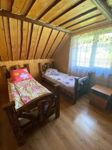 a small room with two beds in a attic at Відпочинок в Карпатах in Nizhne-Studënyy