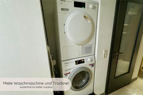 a washing machine in a bathroom next to a door at INVITA Natur-Chalets - Familienurlaub im Schwarzwald in Bad Dürrheim