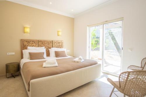 a bedroom with a large bed with towels on it at Casa Quadra Dique in Faro