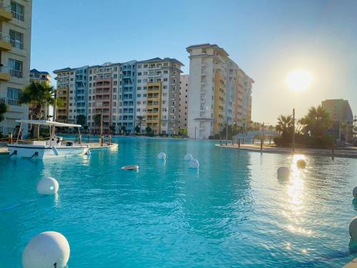 ein Schwimmbad mit Schwänen im Wasser mit Gebäuden in der Unterkunft porto golf marina in El-Alamein