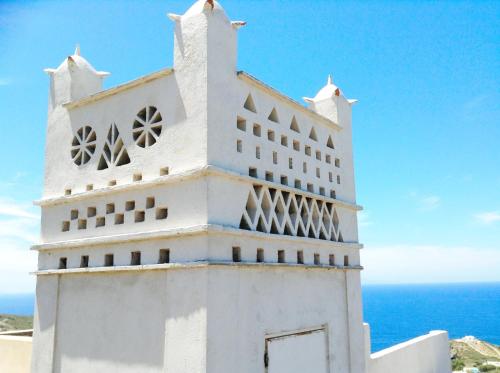 a white building with the ocean in the background at Charakas Horizon in Gavrion