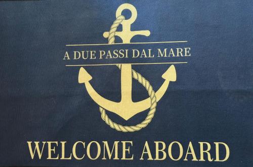 a poster for a webpage board with an anchor at A due passi dal mare 2023 in Nettuno