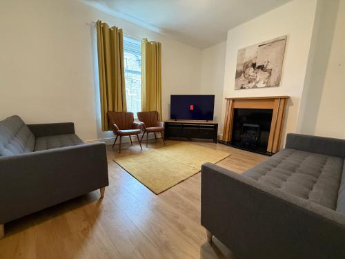 a living room with two couches and a television at Central 3BR Home - Huddersfield Serviced Accomodation - Walk to Station & Town - Business Travellers - Families - Students in Huddersfield