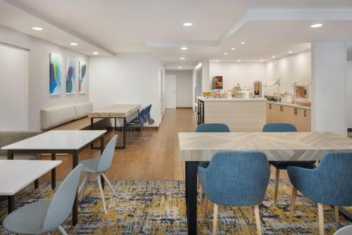 タンパにあるTownePlace Suites Tampa Westshore/Airportのテーブルと椅子、キッチンを備えたカフェテリア
