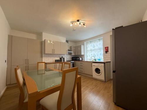 a kitchen with a glass table and chairs in a room at Central 3BR Home - Huddersfield Serviced Accomodation - Walk to Station & Town - Business Travellers - Families - Students in Huddersfield
