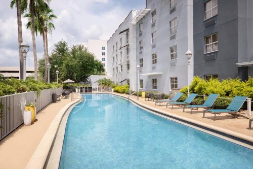 a swimming pool at a hotel with chairs and a building at TownePlace Suites Tampa Westshore/Airport in Tampa