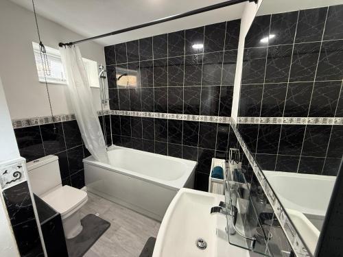 a bathroom with a tub and a toilet and a sink at Central 3BR Home - Huddersfield Serviced Accomodation - Walk to Station & Town - Business Travellers - Families - Students in Huddersfield