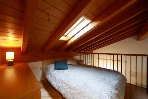 a bedroom with a bed in a wooden attic at Apt 4 Borgo Lago di Garda in Lonato del Garda