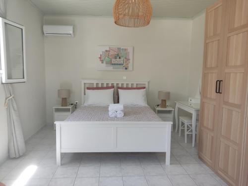 a bedroom with a white bed with two towels on it at Casa Maria Porto Cheli in Porto Heli