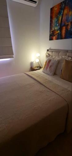 a bedroom with a bed with a painting on the wall at Apartamento 2 Quartos , Ananindeua para C0P30 in Ananindeua