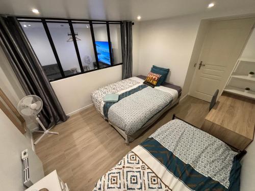 two beds in a room with a window at B0 Appart 2022 - 10min PARIS/EXPO - 5 rooms/6 beds in Bagneux
