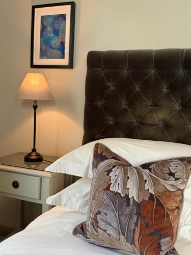 a bed with a black headboard and a table with a lamp at Number 46 in Hastings