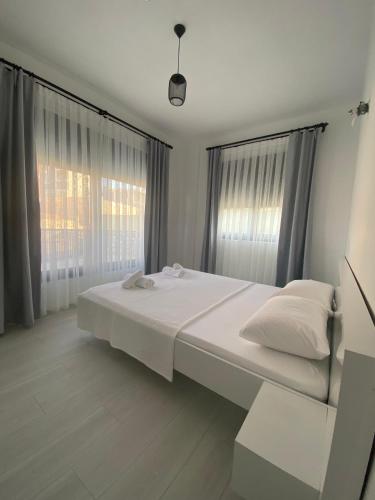a white bed in a room with windows at Doğan Homes Likya in Demre