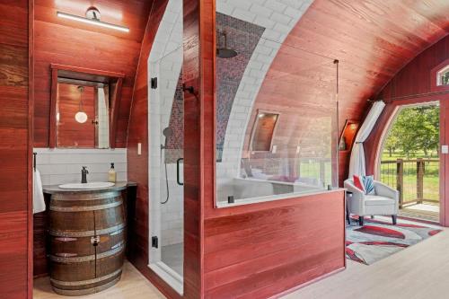 a bathroom with a tub and a sink and a barrel at Cabernet Wine Barrel Cabin in Fredericksburg