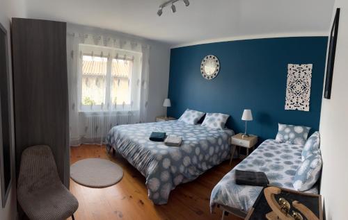 コロンビエ・ソニューにあるMaison 90m2 de 2 à 10 personnesの青いベッドルーム(ベッド2台、窓付)