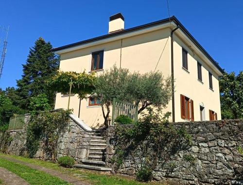 a large white house with a stone wall at Residence Ruje in Prepotto