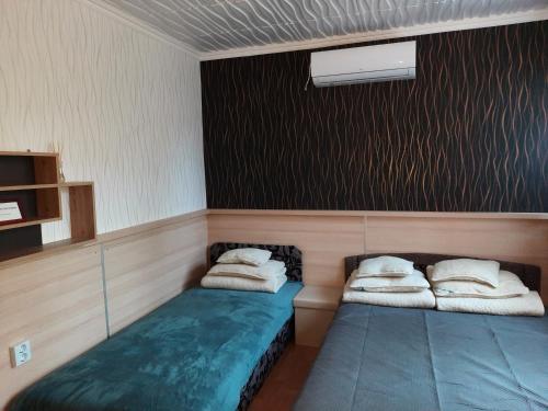 a room with two beds with pillows on them at Fenyves Nyaraló in Hajdúszoboszló