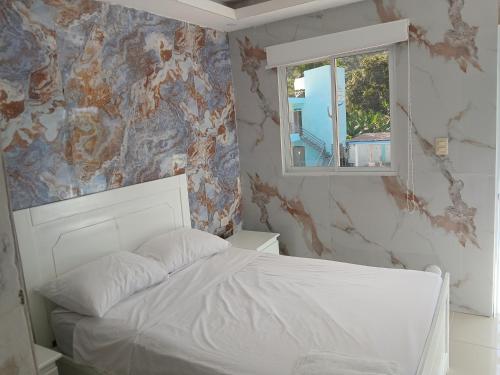 a bedroom with a white bed and a window at Paraíso Vacacional FERNANDO in Polo