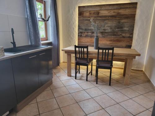 a kitchen with a wooden table and two chairs at Ferienwohnungen beim Silbergersee in Oberaudorf