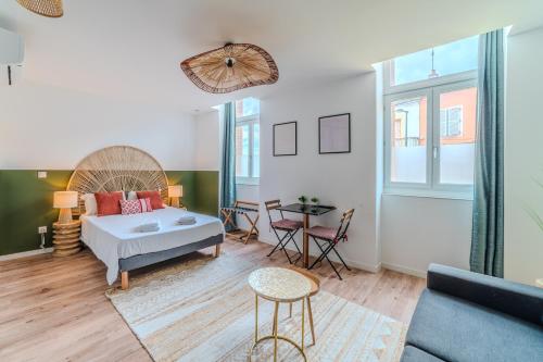 un soggiorno con un letto e un tavolo di Iris Parking & Clim - Roanne centre-ville a Roanne
