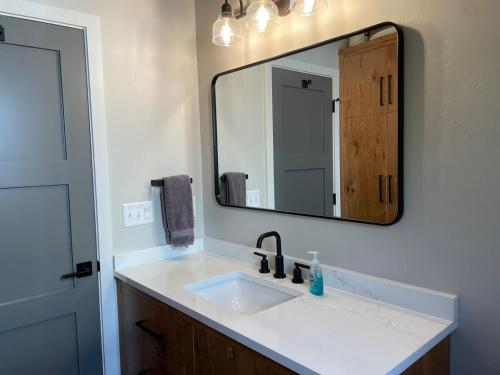 une salle de bain avec un lavabo et un miroir dans l'établissement Cozy Modern Cottage, à Ashland