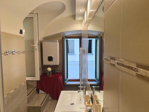 a bathroom with a sink and a large window at 17th Century Vaulted Suite in Turin