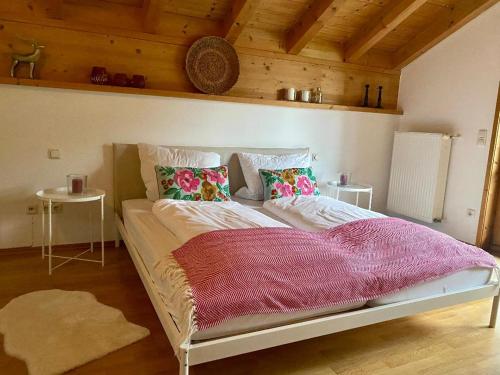 a large bed in a room with wooden ceilings at Maiwand in Flintsbach am Inn