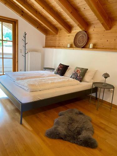 a large bed in a room with a wooden ceiling at Maiwand in Flintsbach