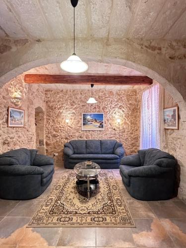a living room with two couches and a table at Traditional Holiday Home in the Heart of Nadur in Nadur