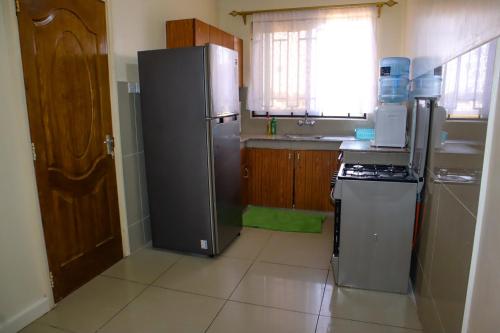 een keuken met een roestvrijstalen koelkast en een fornuis bij Kings Square Tebiz Haven in Eldoret