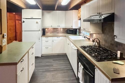 a kitchen with white cabinets and a stove top oven at Wandering Trails Retreat in Cambridge