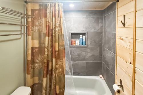 a bathroom with a tub and a shower curtain at Wandering Trails Retreat in Cambridge
