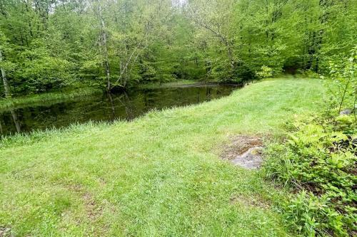 a grassy field next to a river with trees at Wandering Trails Retreat in Cambridge