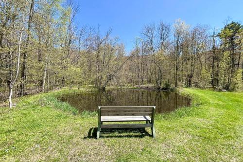 a park bench sitting in the grass next to a pond at Wandering Trails Retreat in Cambridge