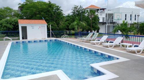 a large swimming pool with chairs and a building at Finca Villa Hayde in Flandes