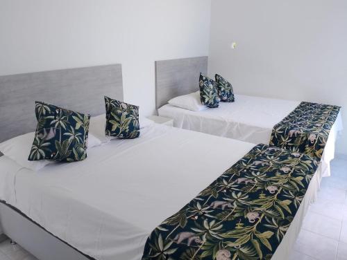 two beds in a room with white sheets and pillows at Finca Villa Hayde in Flandes