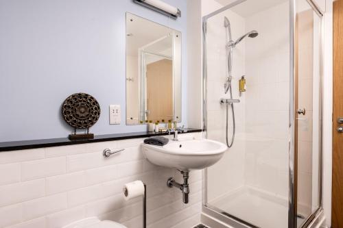 a white bathroom with a sink and a shower at The Highland Club in Fort Augustus