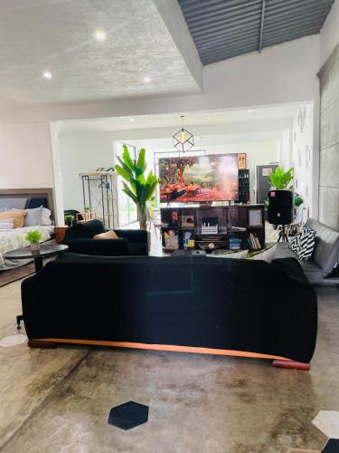 a living room with a large black couch in a room at Loft Industrial Petfriendly in Tlaxcala de Xicohténcatl