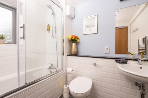 a bathroom with a toilet and a sink at The Highland Club in Fort Augustus