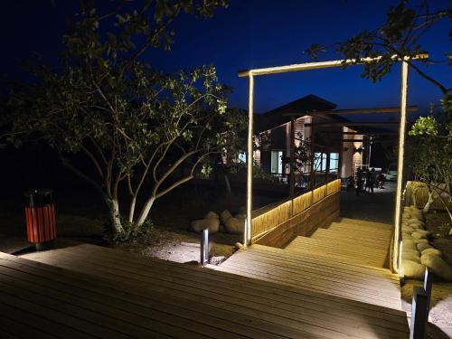 a wooden boardwalk leading to a restaurant at night at EcoHouse Glamping by ART HOTEL in Bishkek