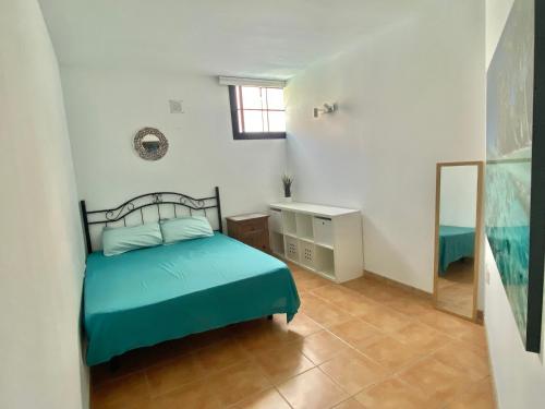 a small bedroom with a bed and a mirror at Atlantic Breeze House in Corralejo
