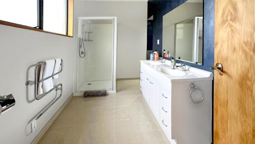 a white bathroom with a sink and a mirror at Spacious 5BR Family Escape on Busch Lane in Christchurch