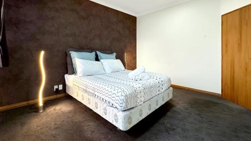 a bedroom with a bed with a white comforter at Spacious 5BR Family Escape on Busch Lane in Christchurch
